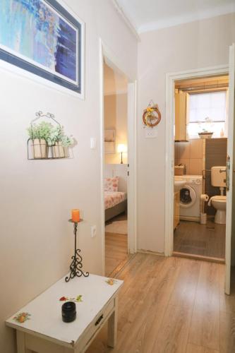 a white room with a table and a bathroom at Kamena kuća in Požega
