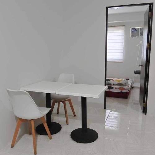 einen weißen Tisch und zwei Stühle in einem Zimmer in der Unterkunft Piper Condo at Urban Deca in Mandaue City