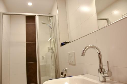a bathroom with a sink and a shower at Haus Sandkorn in Baltrum