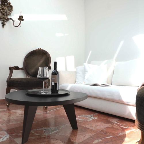 a living room with a couch and a table with a bottle of wine at Hotel Forstinger - Boutique Hotel Schärding in Schärding