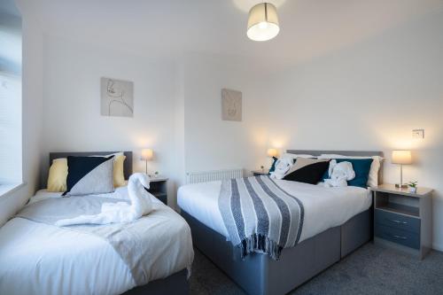 two beds sitting next to each other in a bedroom at Modern - 2 Bed - Free Parking in Coxhoe