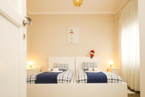 a bedroom with two beds with blue and white blankets at Kamena kuća in Požega