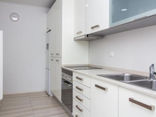 a white kitchen with a sink and a stove at Villa Double Joy by Stay ici in Albufeira