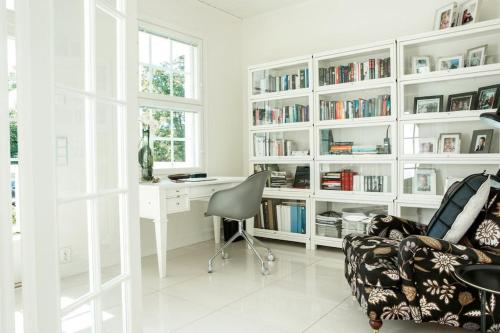 Una habitación blanca con un escritorio y una silla. en White House, en Kokkola