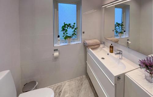 a white bathroom with a sink and a toilet at Lovely Home In Kumla With Kitchen in Kumla