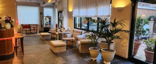 un salone con sedie e piante in una stanza di Hotel La Capannina a Genova