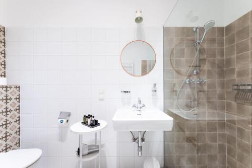 een witte badkamer met een wastafel en een douche bij HM • Sleek 1BR Flat Near Center in Wenen