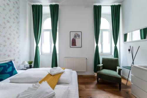 een slaapkamer met 2 bedden en een groene stoel bij HM • Sleek 1BR Flat Near Center in Wenen