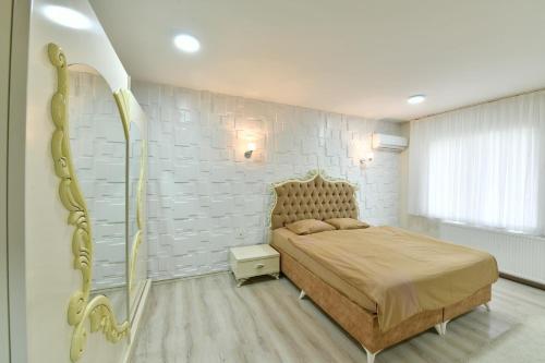 イスタンブールにあるDubleks Suite 3-1の白レンガの壁、ベッド付きのベッドルーム1室
