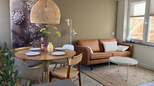 sala de estar con mesa y sofá en Bundi Beach, en Egmond aan Zee
