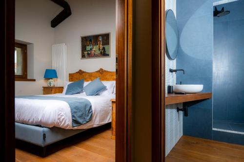 a bedroom with a bed and a bathroom with a sink at 1448 Antica Dimora Al Merlo Bianco in Cividale del Friuli