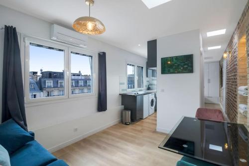 un salon avec un canapé et deux fenêtres dans l'établissement 1 Bedroom#Haussmann#Amazing view#EffeilTower#AC, à Paris