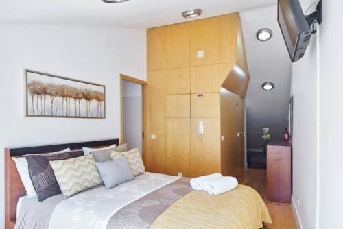 a bedroom with a large bed and a tv at University View Loft in Coimbra