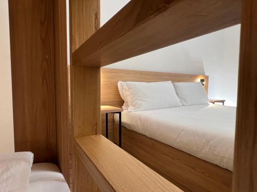 - une chambre avec un lit et une tête de lit en bois dans l'établissement YUGOGO MAZZINI 41 Trento Centro, à Trente