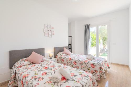 Un dormitorio con dos camas y una ventana. en Ferrera Soul 1b, en Santanyí