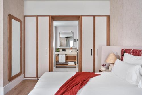 a bedroom with a white bed and a mirror at Boutique Hotel Posada Terra Santa in Palma de Mallorca