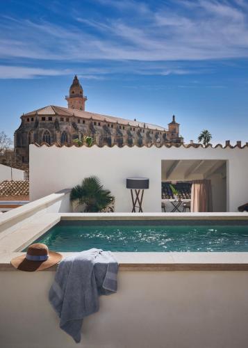 a hat and a towel sitting next to a swimming pool at Boutique Hotel Posada Terra Santa in Palma de Mallorca