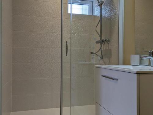 une douche avec une porte vitrée à côté d'un lavabo dans l'établissement Studio confort à Angoulême avec terrasse, proche transports, idéale pour couples et bébés. - FR-1-653-231, à Angoulême