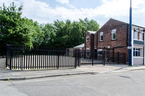 a black wrought iron fence in front of a brick building at Trivelles Eccles in Manchester