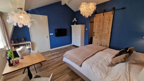 a bedroom with blue walls and a bed and a table at B&B De Droomhoeve in Nunspeet