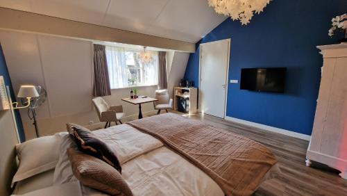 a bedroom with a large bed and a blue wall at B&B De Droomhoeve in Nunspeet