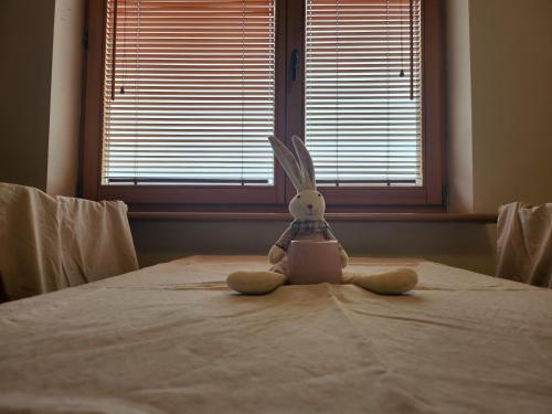 a stuffed rabbit sitting on a bed with a laptop at Nature in Kraków