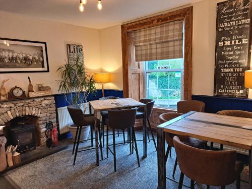 a dining room with tables and a fireplace at The Ship Inn in Bardsea