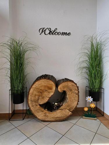 a large wooden pretzel sitting on a floor with two plants at Gästehaus Heinrich Heine Schule in Bad Dürrenberg