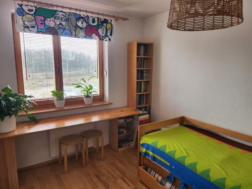 Schlafzimmer mit einem Bett, einem Schreibtisch und einem Fenster in der Unterkunft Nature in Krakau