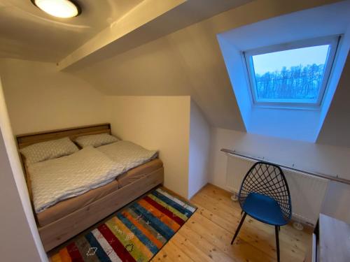 a small bedroom with a bed and a blue chair at Apartmán - Dovolená Mladé Buky in Mladé Buky