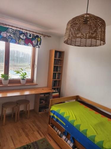 a bedroom with a bed and a desk and a window at Nature in Kraków