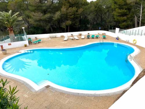 Una gran piscina azul en un patio. en Appartement vue sur golf Son Parc Menorca, en Son Parc