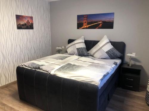 Schlafzimmer mit einem Bett mit schwarzem Kopfteil in der Unterkunft Ferienwohnung Hubertus in Irsch