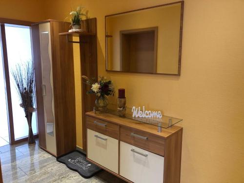 a bathroom with a dresser and a mirror on the wall at Ferienwohnung Hubertus in Irsch