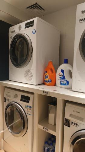 a laundry room with a washer and dryer on a shelf at Paco Hotel Dongpu Guanghzou -Free Shuttle Bus for Canton Fair in Guangzhou
