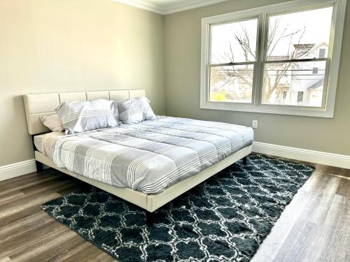 a bed in a bedroom with a window and a rug at Belmar NJ 5 Min Walk to Beach, Sleeps 16+ in Belmar