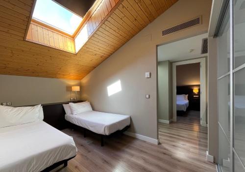a bedroom with two beds and a skylight at HG La Molina in La Molina