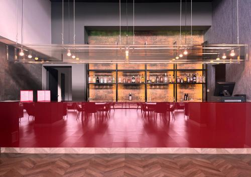 a dining room with a bar with red tables and chairs at HG La Molina in La Molina