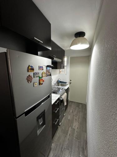 a kitchen with a stainless steel refrigerator and a stove at Departamento en Torres Reyes ll in Tijuana