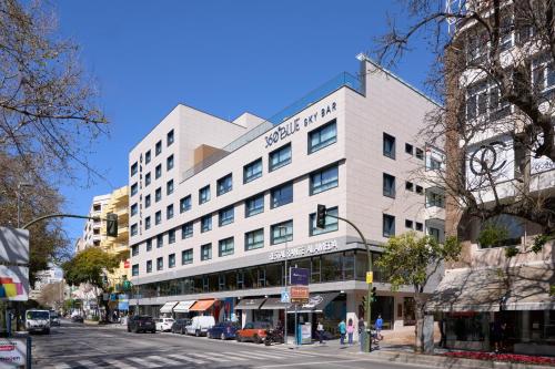un gran edificio blanco en una calle de la ciudad en Óbal Urban Hotel en Marbella