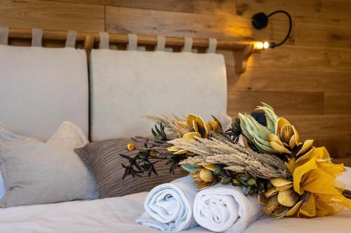 a bouquet of flowers sitting on top of a bed at Tuscany Living - Terra Antica in Montepulciano