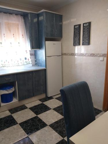 cocina con nevera y suelo a cuadros en Casa Benzambra, en Cádiar