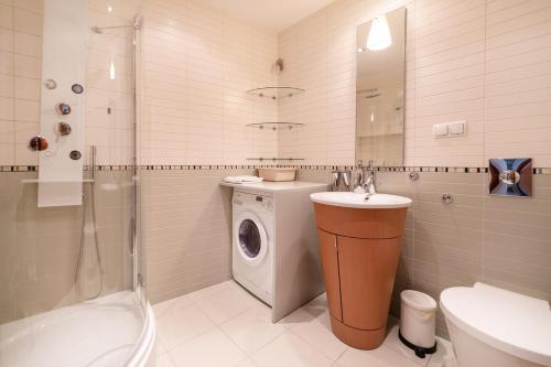 uma casa de banho com uma máquina de lavar roupa e um lavatório em Apartament 36 Międzymorze 10 em Jurata