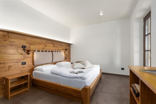 a bedroom with a bed with a wooden headboard at Tuscany Living - Terra Antica in Montepulciano