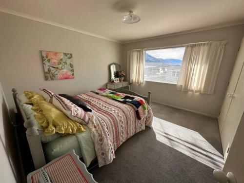 a bedroom with a bed and a large window at Character on Capell large house perfect for extended family in Lake Hawea