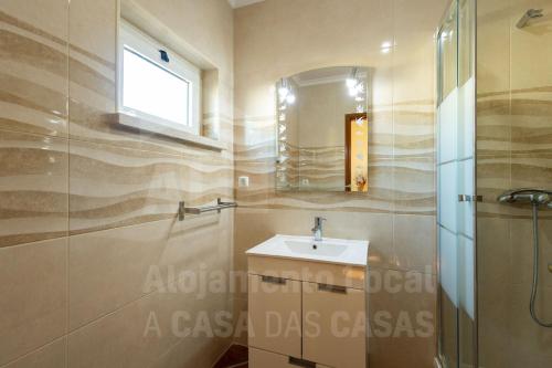 a bathroom with a sink and a mirror at Sea & Sunset by AcasaDasCasas in Ericeira