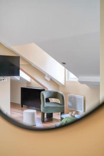 un miroir reflétant une pièce avec une chaise et un escalier dans l'établissement 4G#Appart 8Pers # 3 Chambres # Commerce # Paris 15#AC, à Paris