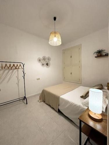 - une chambre avec un lit, une table et une lampe dans l'établissement Apartamento Calle Puentezuelas, à Grenade