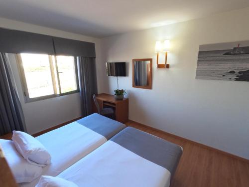 a hotel room with two beds and a window at Hotel Saylu in Granada