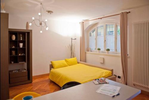 een slaapkamer met een geel bed en een tafel bij Tricolore - Sottocorno Charme Loft in Milaan